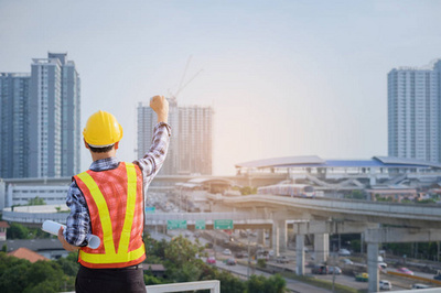 工程師或建筑師與防護安全帽檢查建筑圖紙呼叫支持團隊在建筑工地。工程建筑和建筑施工理念。軟焦點